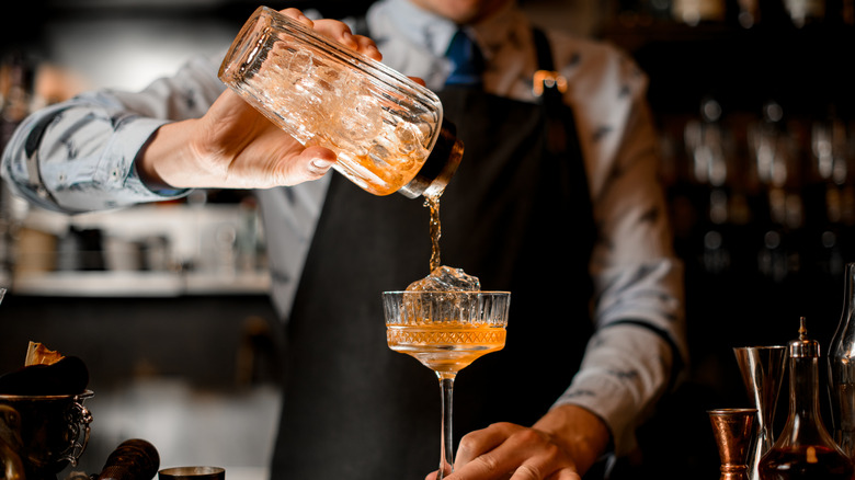 Barman,Gently,Pours,Finished,Cocktail,From,Glass,Shaker,Into,Glass.